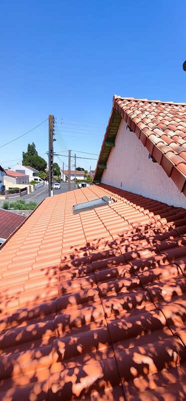 Travaux de peinture sur une toiture en tuiles