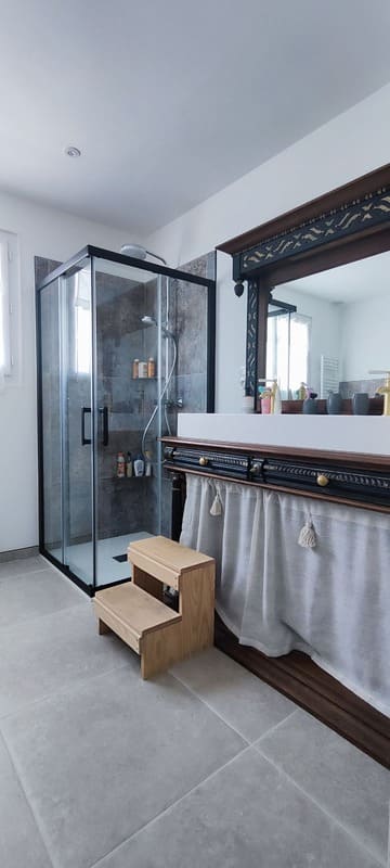 Douche avec parois vitrées noires après rénovation de salle de bain